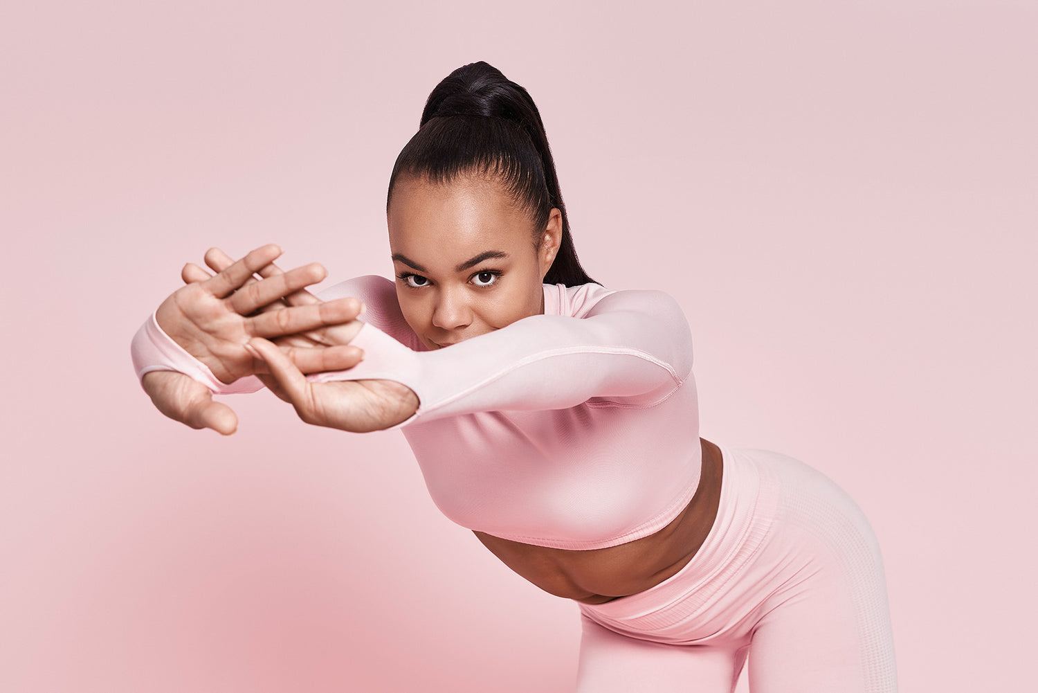 Woman wearing pink workout clothes stretching